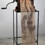 Antique laundry wringer with painted silk cloth on metal stand.