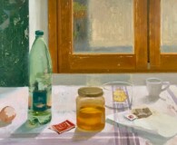 Egg shell, bottle of water, jar of honey, tea bag and cup by the window.