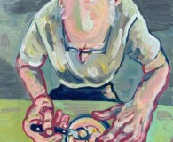 Older white male sitting at a table, eating a grapefruit.